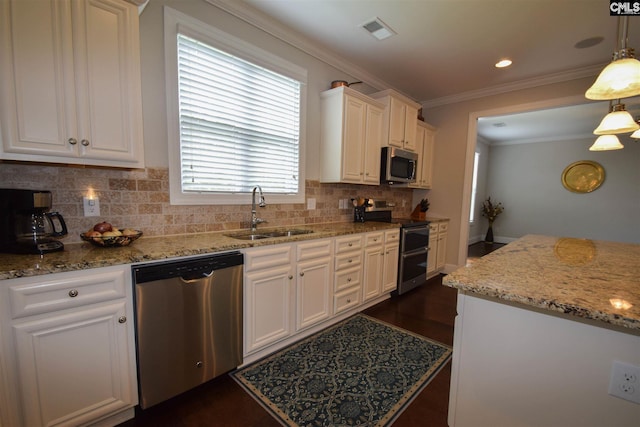 kitchen featuring sink, backsplash, appliances with stainless steel finishes, and pendant lighting