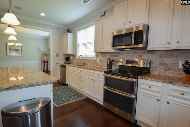 kitchen featuring white cabinets, appliances with stainless steel finishes, light stone countertops, and dark hardwood / wood-style flooring