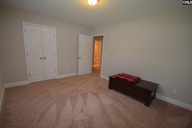 unfurnished bedroom with a closet and light colored carpet