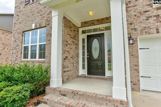 entrance to property featuring a porch and a garage