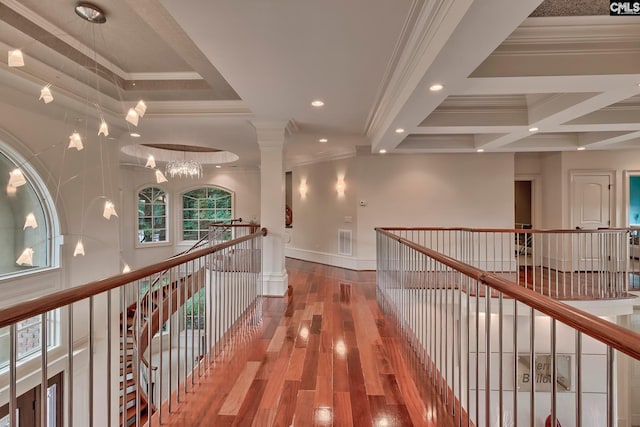 hall with coffered ceiling, hardwood / wood-style flooring, crown molding, a notable chandelier, and beam ceiling