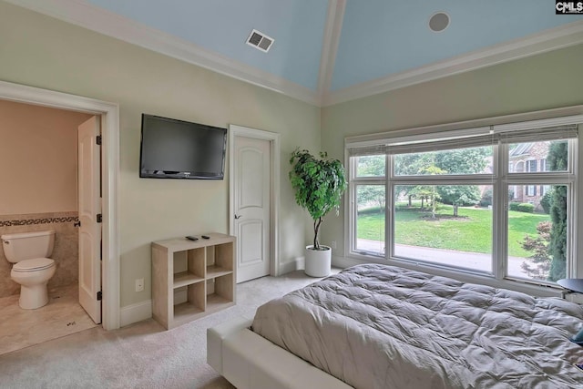 tiled bedroom featuring ensuite bath, ornamental molding, and vaulted ceiling