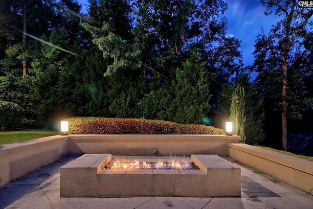 patio terrace at night featuring a fire pit