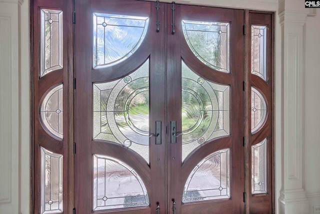 entrance foyer featuring decorative columns and french doors