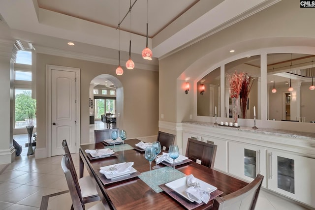 tiled dining room featuring plenty of natural light and a raised ceiling