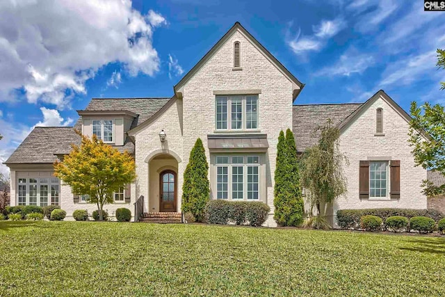 tudor home featuring a front lawn