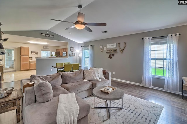 living room with lofted ceiling, ceiling fan, and hardwood / wood-style flooring