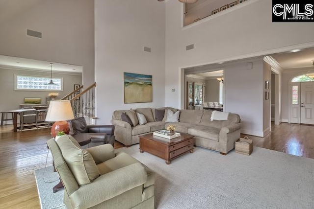 living room with a high ceiling, a chandelier, and wood-type flooring