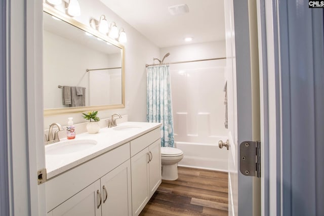 full bathroom featuring hardwood / wood-style floors, large vanity, dual sinks, toilet, and shower / tub combo with curtain