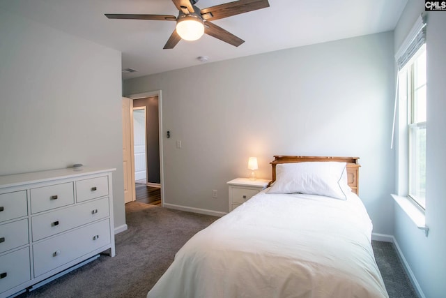 bedroom featuring multiple windows, dark colored carpet, and ceiling fan