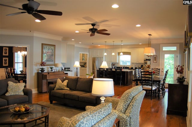 living room with hardwood / wood-style flooring, ceiling fan with notable chandelier, and a healthy amount of sunlight