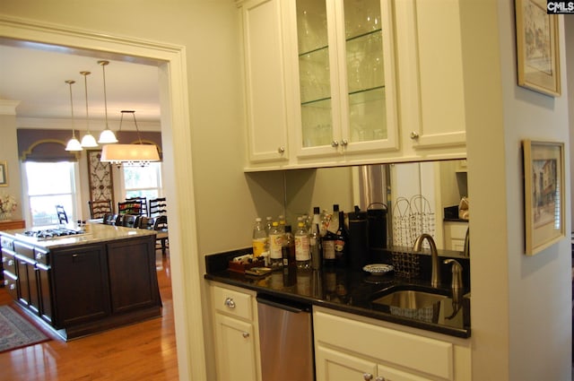 kitchen featuring white cabinets, sink, and pendant lighting