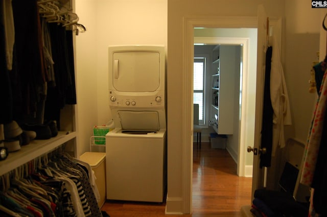 interior space with stacked washer / drying machine and hardwood / wood-style flooring