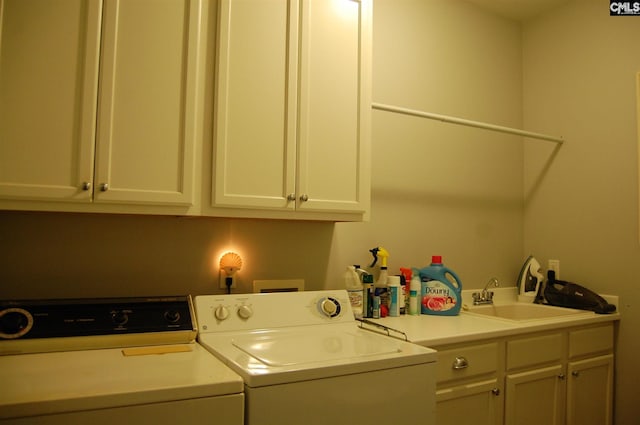 laundry area featuring cabinets, independent washer and dryer, and sink