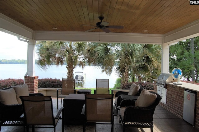 view of terrace with grilling area, area for grilling, a water view, and ceiling fan