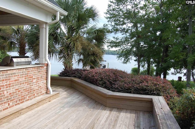 wooden deck featuring area for grilling and a water view