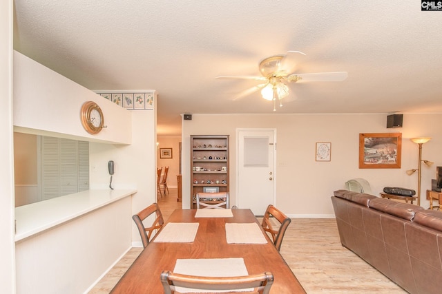 dining room featuring ceiling fan, a textured ceiling, and light hardwood / wood-style floors