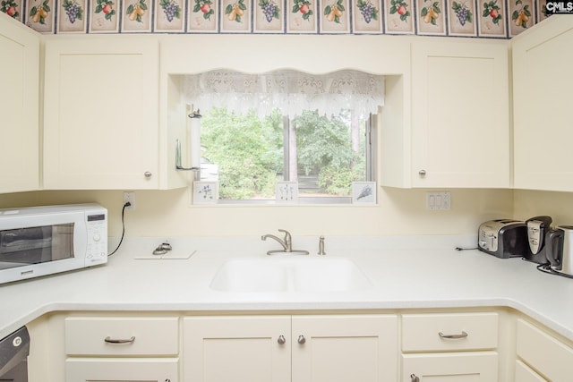 kitchen featuring white cabinets, sink, and dishwasher