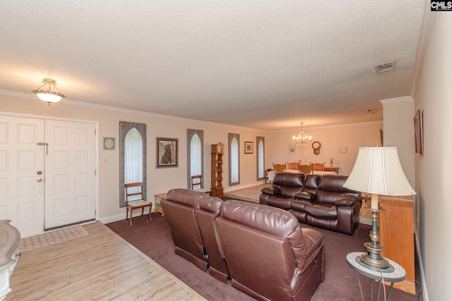 living room featuring a textured ceiling, ornamental molding, a chandelier, and hardwood / wood-style floors