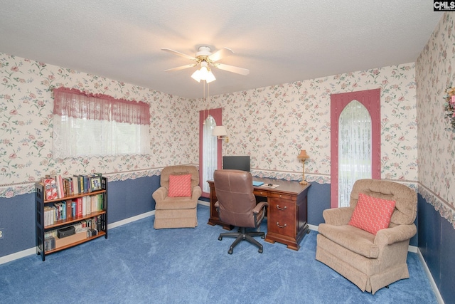 home office featuring ceiling fan, dark carpet, and a textured ceiling