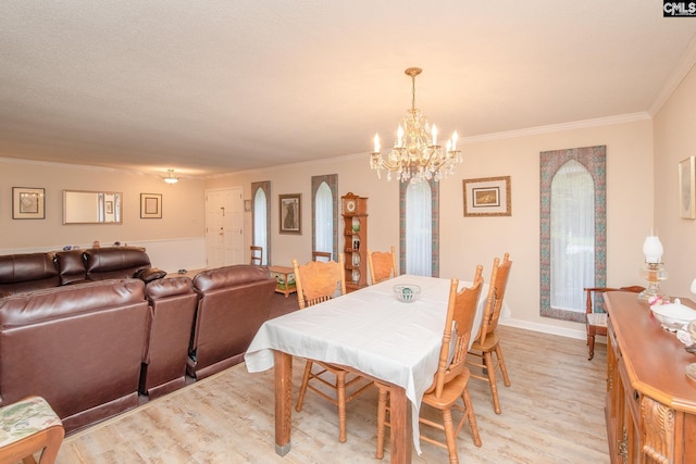 dining area featuring crown molding, a chandelier, and light hardwood / wood-style flooring