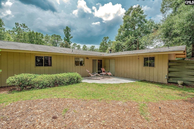 rear view of property featuring a yard and a patio area