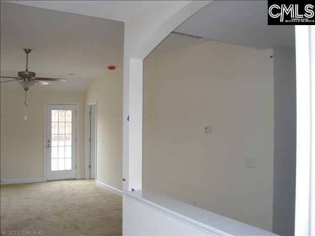 corridor featuring light carpet and lofted ceiling