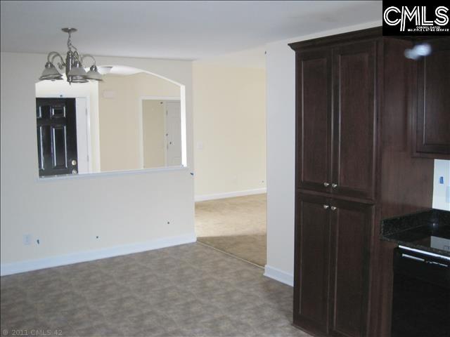 kitchen featuring dark brown cabinets, a chandelier, light carpet, and black dishwasher