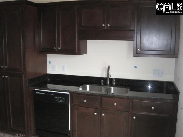 kitchen with dark brown cabinets, dark stone counters, sink, and dishwasher