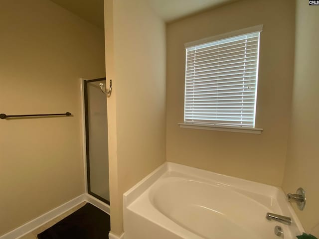 bathroom featuring shower with separate bathtub