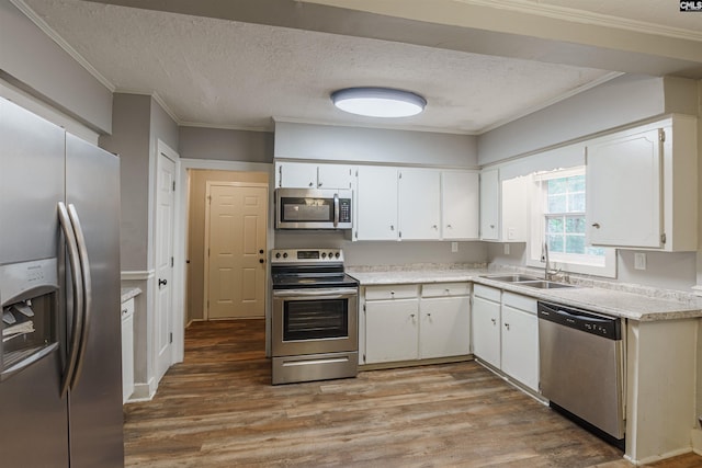 kitchen featuring hardwood / wood-style flooring, white cabinetry, sink, and stainless steel appliances