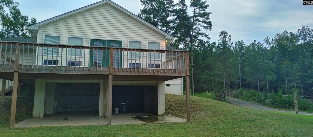 back of house with a yard and a garage