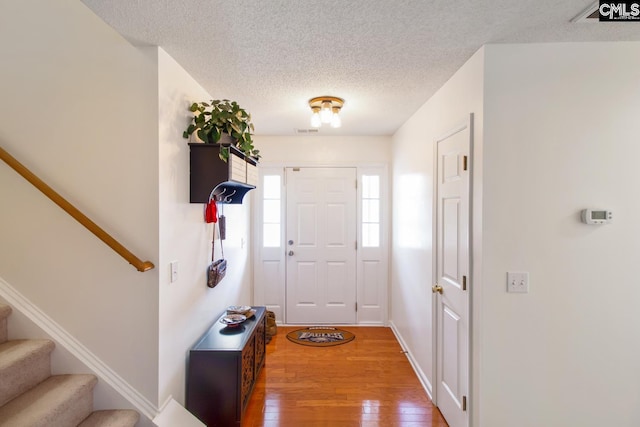 foyer featuring a textured ceiling and hardwood / wood-style flooring