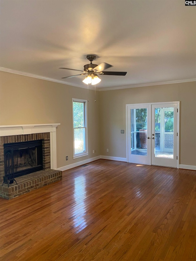 unfurnished living room with dark hardwood / wood-style floors, a brick fireplace, a healthy amount of sunlight, and ceiling fan