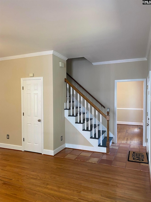 stairs with crown molding and dark tile floors