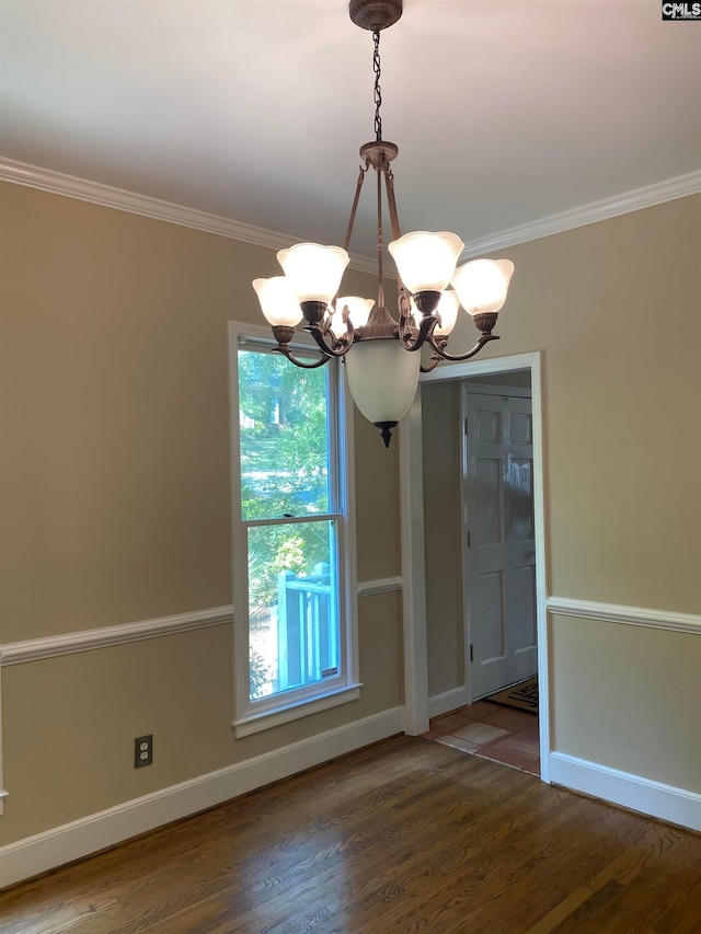 unfurnished room featuring an inviting chandelier, crown molding, and dark wood-type flooring