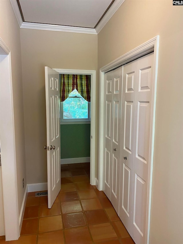 corridor featuring ornamental molding and light tile floors