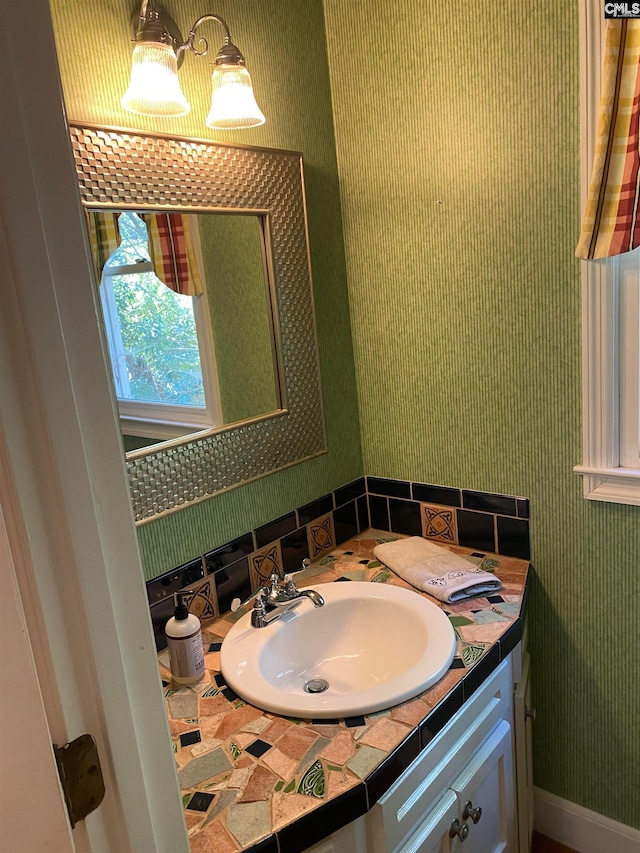 bathroom featuring tasteful backsplash and vanity with extensive cabinet space