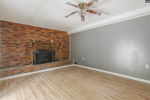 unfurnished living room with brick wall, a fireplace, ceiling fan, and light hardwood / wood-style flooring