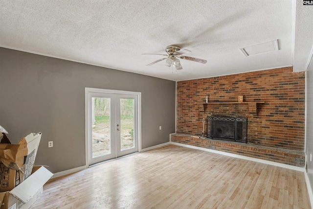 living room featuring brick wall, a textured ceiling, ceiling fan, and light wood-type flooring