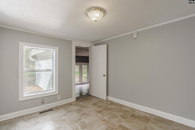 tiled empty room featuring a textured ceiling and ornamental molding