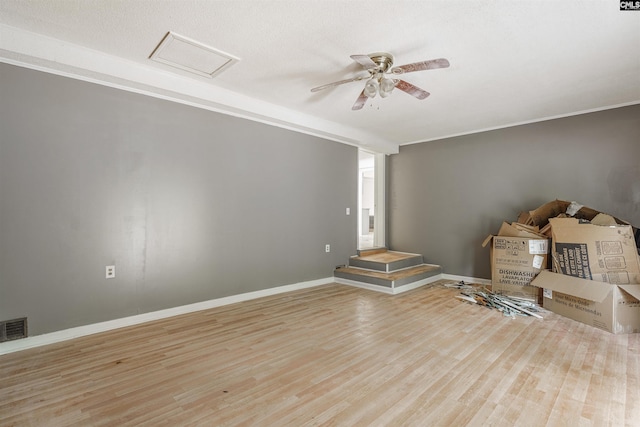 spare room with a textured ceiling, ceiling fan, and light wood-type flooring