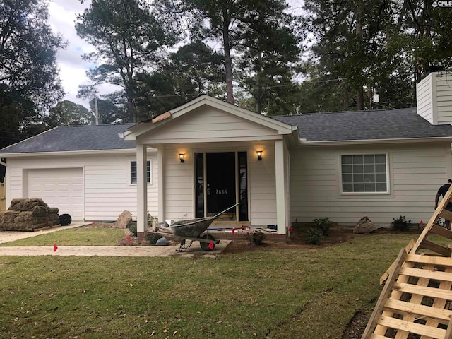 view of front of house featuring covered porch, a front lawn, and a garage