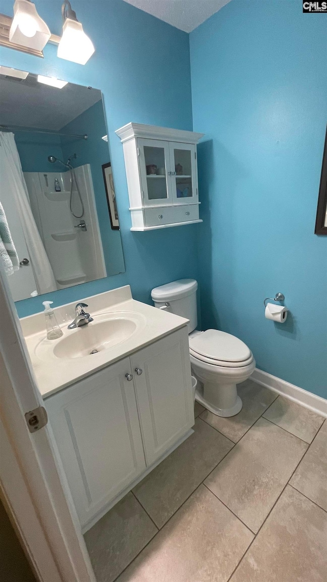 bathroom featuring toilet, tile floors, and vanity