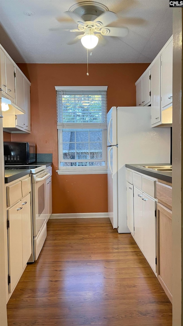 kitchen featuring light hardwood / wood-style floors, white cabinets, ceiling fan, and white electric range