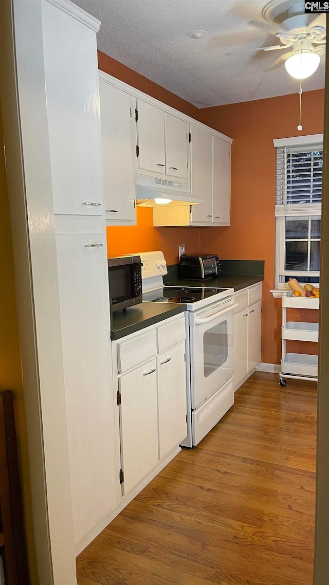 kitchen featuring white range with electric cooktop, white cabinetry, ceiling fan, and light wood-type flooring