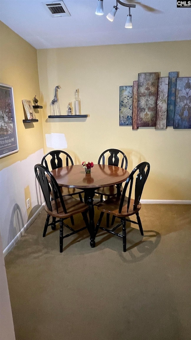 carpeted dining area featuring ceiling fan and track lighting