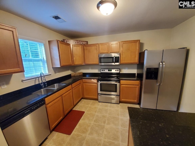 kitchen featuring light tile flooring, appliances with stainless steel finishes, and sink