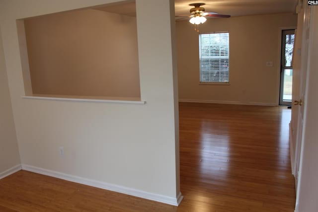 empty room with ceiling fan and dark hardwood / wood-style flooring