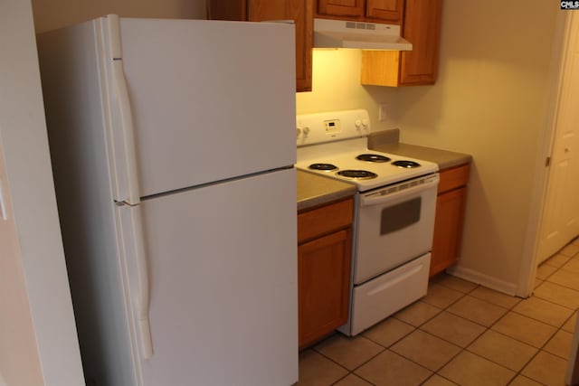 kitchen featuring fume extractor, white appliances, and light tile floors